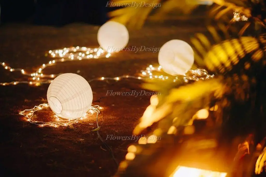 Elegant glowing outdoor lanterns with fairy lights designed by Flowers By Design